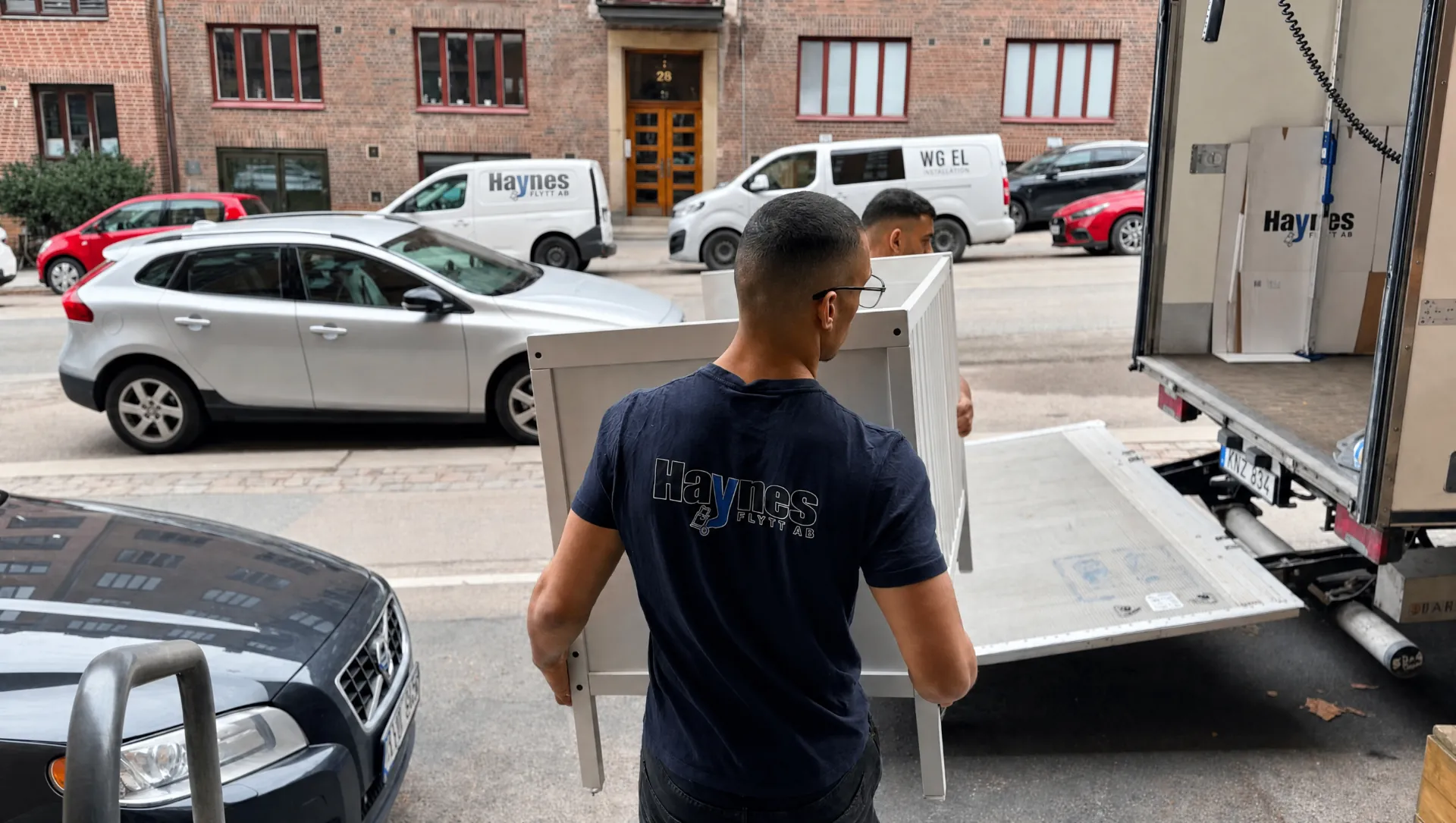 Haynes Flytt, flyttare bär möbler ut ur trapphus